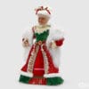 Figura natalizia di Mamma Natale con abito in velluto verde e rosso, decorazioni in pizzo oro, cappello bianco con fiocchi e occhiali dorati.