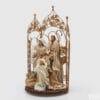 Presepe in tessuto EDG con Sacra Famiglia e angelo, decorato con cancello dorato floreale e abiti eleganti dai toni neutri.