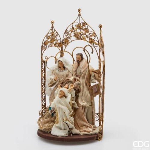 Presepe in tessuto EDG con Sacra Famiglia e angelo, decorato con cancello dorato floreale e abiti eleganti dai toni neutri.