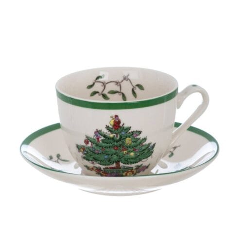 Tazza da tè con piattino in ceramica bianca decorata con albero di Natale, bordo verde e dettagli natalizi.