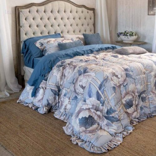 Trapunta matrimoniale Blanc MariClo collezione Peonies con fantasia floreale azzurra e balza arricciata, completa di due copriguanciali coordinati.