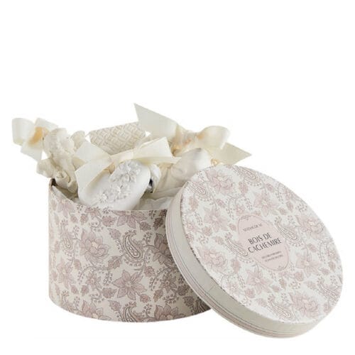 Cofanetto rotondo floreale con decori in gesso bianco profumato e nastri avorio, fragranza Bois de Cachemire.