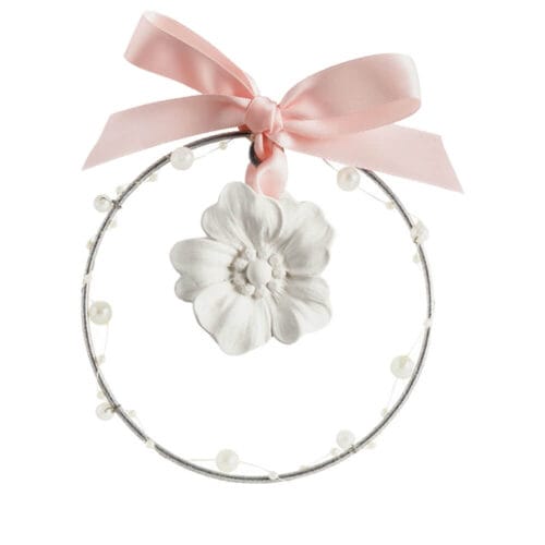 Corona profumata Mathilde M con fiore in gesso bianco e nastro rosa, decorata con perle su cerchio metallico, confezionata in scatola rosa decorata.