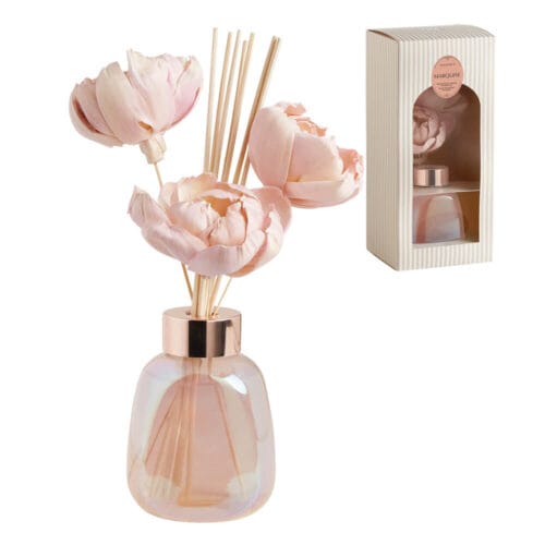 Diffusore per ambienti Mathilde M con fiori decorativi rosa in manioca e bastoncini in rattan, contenuto in un elegante flacone in vetro rosato iridescente.