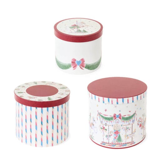 Set di tre scatole rotonde decorate con fantasie natalizie ispirate a giostre e cavalli a dondolo, con coperchio rosso e dettagli in stile vintage.