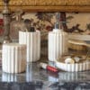 Set bagno in ceramica bianca lucida composto da dispenser, bicchiere, barattolo con coperchio e piattino, tutti con decoro scanalato elegante.