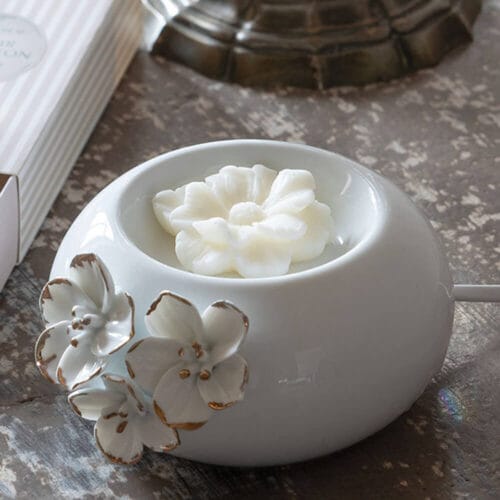 Brûle-parfum elettrico in ceramica bianca con decoro floreale dorato, utilizzato con cera profumata Mathilde M.