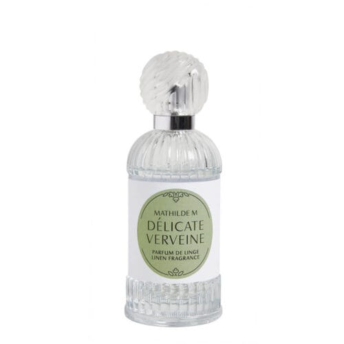 Flacone di profumo per tessuti Mathilde M Délicate Verveine da 75 ml in vetro trasparente con rilievi verticali e tappo trasparente zigrinato, etichetta verde salvia.