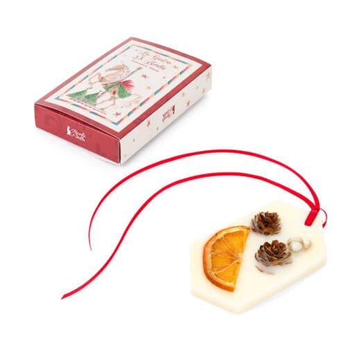 Profumatore per cassetti in cera decorato con arancia essiccata, pigne e nastro rosso, in scatola regalo illustrata.