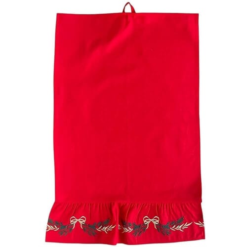 Canovaccio rosso con balza decorata da fiocchi dorati e rametti verdi ricamati, in stile natalizio.