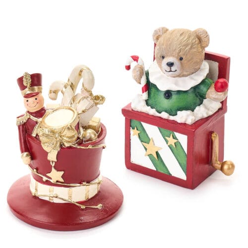 Coppia di decorazioni natalizie in resina: orsetto in carillon e soldatino con tamburo su cappello rosso, ricchi di dettagli dorati.