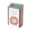 Scatola in cartone con stampa ghirlanda natalizia e scritta “Christmas is Coming…”, fessura superiore e bordi scozzesi verdi e rossi.