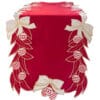 Runner natalizio in velluto rosso con ricami dorati, fiocchi bianchi e palline decorative sui bordi.