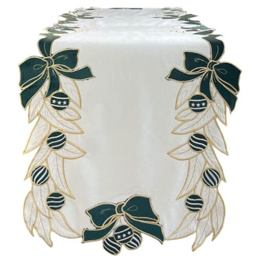 Runner natalizio in velluto bianco con ricami oro, fiocchi verdi e palline decorative a righe e stelle.