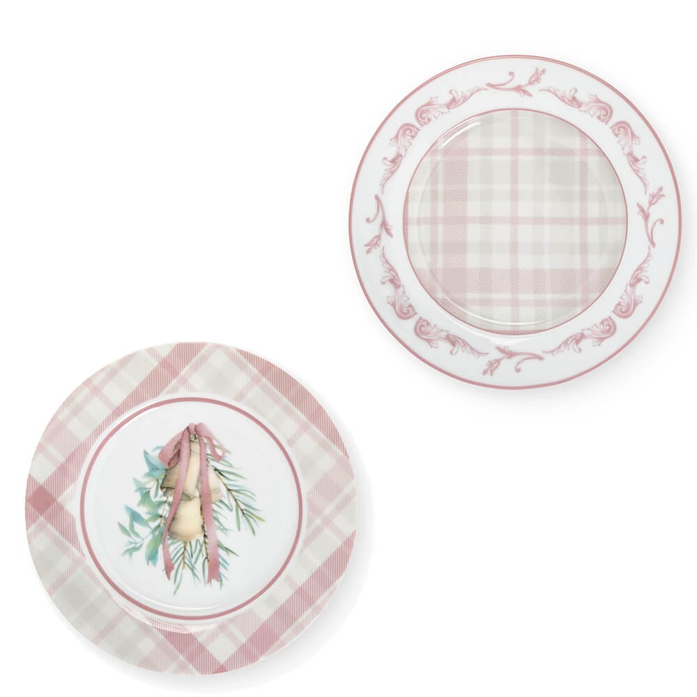Set di due piatti da dolce in porcellana con motivi rosa: uno con campanelle natalizie, l’altro con fantasia scozzese e decoro ornamentale.