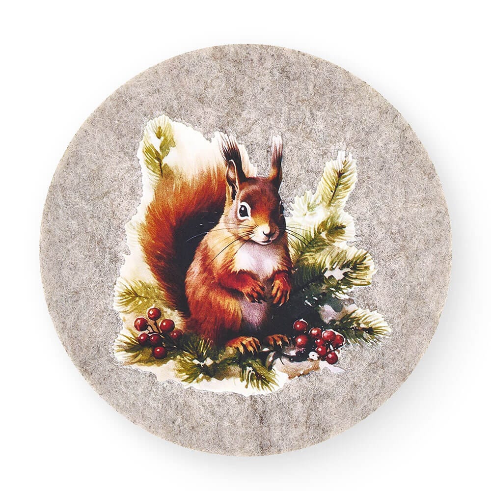 Tovaglietta rotonda in feltro con scoiattolo tra rami di pino e bacche rosse, collezione Bosco Incantato.