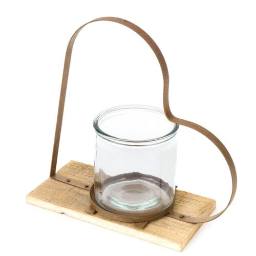 Portacandela con struttura a cuore in metallo, base in legno e bicchiere in vetro per candela.