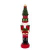 Candela in cera a forma di Schiaccianoci con cappello ad albero di Natale e pacchi regalo, nei toni del rosso, verde e oro.