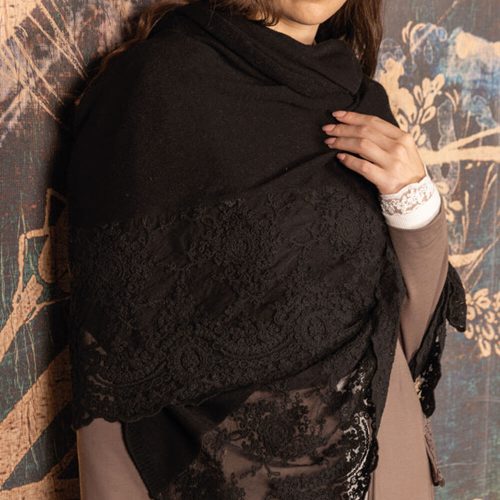 Stola invernale nera con elegante balza in pizzo Corinzio tono su tono, indossata da una donna con guanti coordinati, perfetta per look formali o da sera.