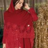 Stola invernale color mosto con balza in pizzo Corinzio tono su tono, indossata da una donna in ambiente elegante, con fondo dorato decorativo.