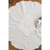Tovaglietta in cotone bianco con ricamo tono su tono e bordo smerlato, decorata con confetti bianchi in conchiglia argentata.