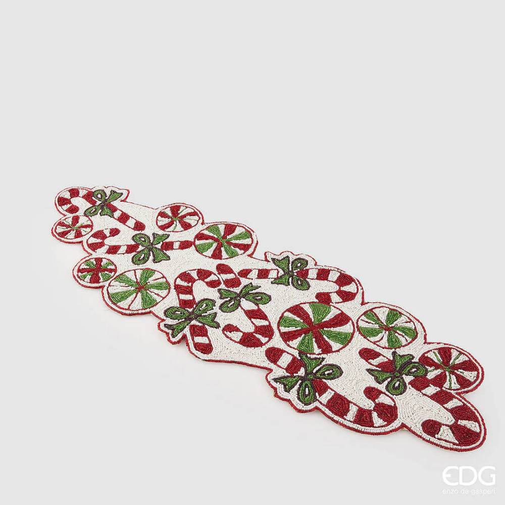 Camino de mesa navideño de EDG decorado con abalorios con motivos de bastones de caramelo, lazos verdes y caramelos, sobre un fondo color crema.