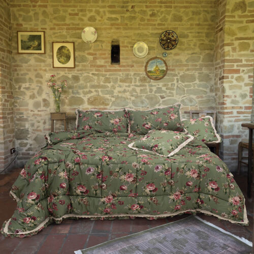 Colcha doble verde con motivos florales y cenefa de encaje sangallo, con fundas de almohada a juego.