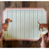 Tovaglietta decorativa in vinile con righe verdi e profilo rosa, raffigurante un cane bassotto stilizzato ai lati.