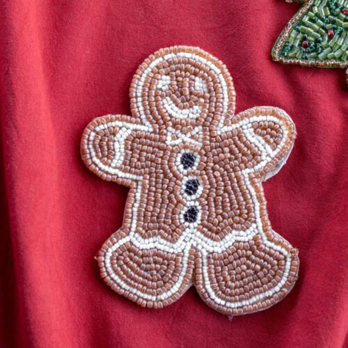 Set di sei sottobicchieri a forma di omino di pan di zenzero, realizzati con perline color biscotto e bianco, su sfondo rosso.