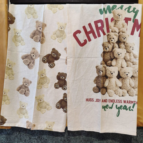 Lot de deux torchons de Noël en coton, l'un avec des ours beiges et bruns sur un fond clair, l'autre avec un ours en forme d'arbre de Noël et l'inscription 'Merry Christmas'.