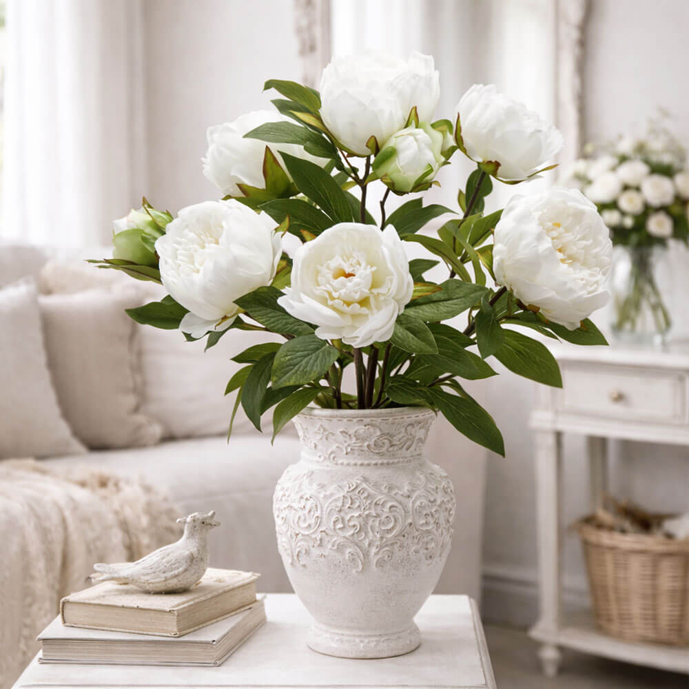 Cespuglio artificiale di peonia avorio con otto fiori e foglie verdi, altezza 53 cm.