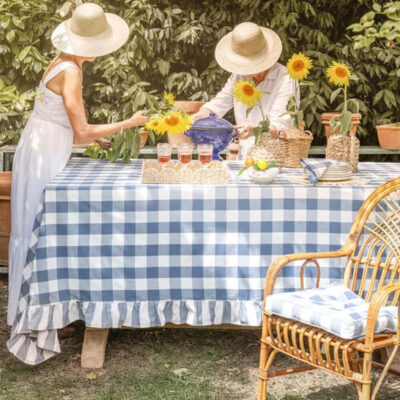 Nappe rectangulaire bleu clair avec motif Vichy et volant décoratif, idéale pour les tables Country Chic à l'extérieur ou dans une véranda.