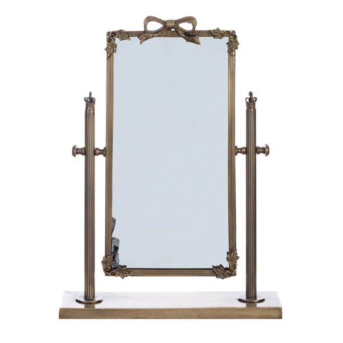 Espejo de mesa con base rectangular, marco de metal antiguo y lazo decorativo en la parte superior.