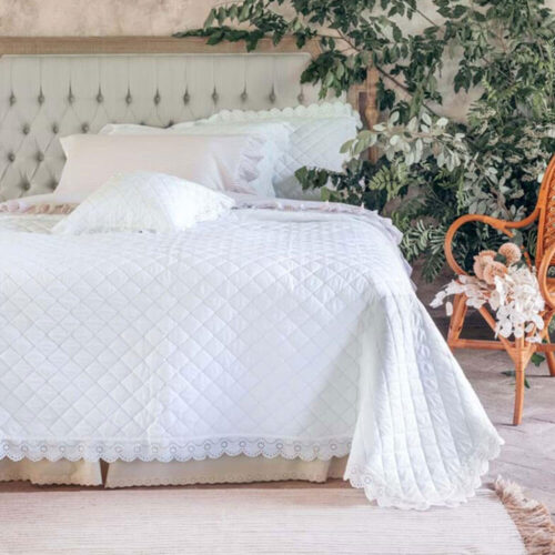 Trapunta matrimoniale bianca Blanc MariClo’ con trapuntatura a rombi e ampia gala in pizzo sangallo traforato lungo il perimetro, con due federe coordinate.