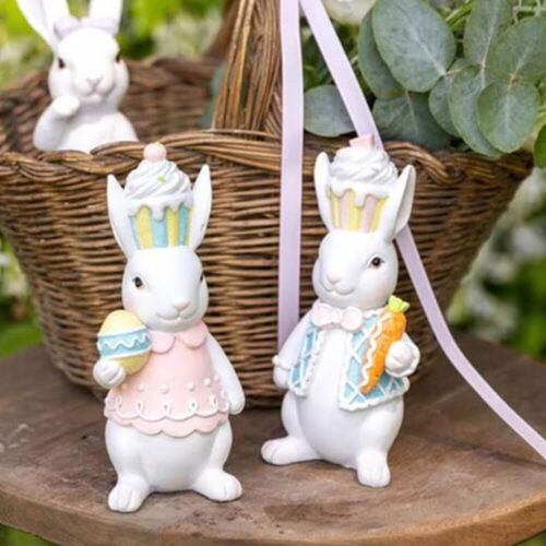 Coppia di coniglietti Blanc Mariclò in resina con cappelli cupcake, uovo decorato e carota glitterata. Stile dolce e pasquale.