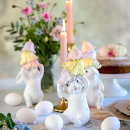 Coniglietto decorativo in resina bianca con tre campanelle floreali color pastello sulla testa, disponibile in 3 varianti.