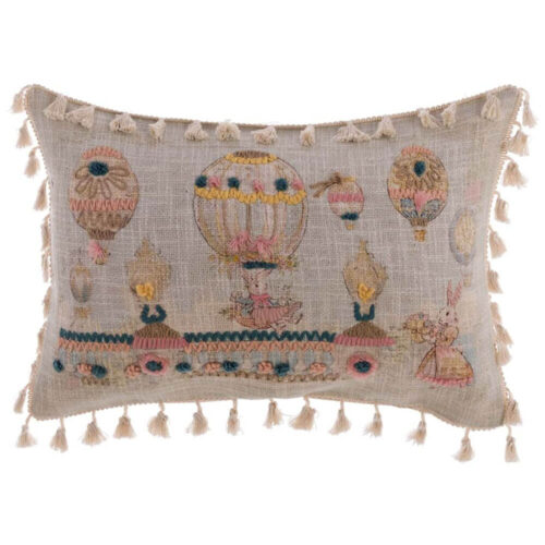 Cuscino decorativo ricamato con mongolfiere e coniglietti su fondo beige, frange in cotone sui bordi.