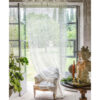 Rideaux en dentelle de filet ivoire "Blanc MariClo" avec motif floral ajouré et bords festonnés, accrochés à une porte-fenêtre dans un intérieur Shabby Chic.