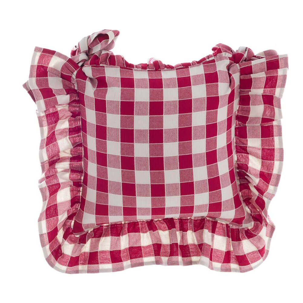 Blanc MariClo’ copricuscino vichy rosso 40x40 1 Copricuscino quadrato Blanc MariClo’ a quadri vichy rosso/bianco con balza arricciata e fiocchi ai lati, appoggiato su sedia in legno stile rustico.