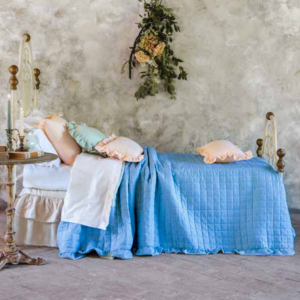 Blanc MariClo' Doble acolchado Sogno Vichy 260x260 1 Colcha doble de cuadros vichy azules "Blanc MariClo" con borde de volante fruncido, colocada sobre una romántica cama de estilo shabby.