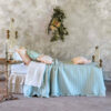 Trapunta matrimoniale verde con stampa vichy e balza arricciata, stile romantico shabby chic su letto in ferro battuto.