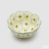 Ciotola rotonda in ceramica con fiori in rilievo bianco crema, profili verde salvia e centri verdi puntinati, diametro 14 cm.