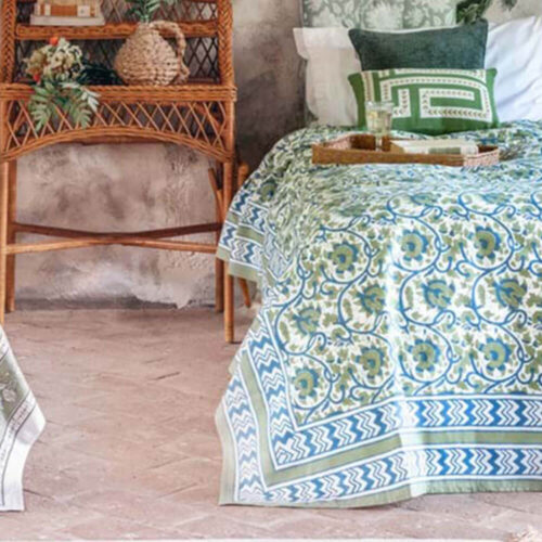 Copritutto Blanc Mariclò in cotone con stampa floreale blu e verde e bordi geometrici decorativi.