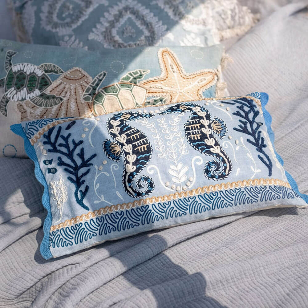 Cuscino decorativo azzurro Blanc Mariclò con ricami marini a cavallucci, coralli e bordi ondulati blu