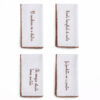 Lot de 4 serviettes de table en coton blanc Blanc MariClò avec lettres brodées et bordure décorative marron.
