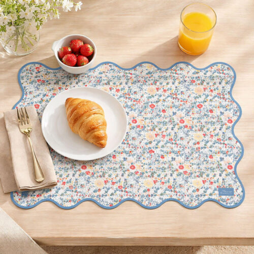 Tovaglietta Blanc Mariclò in vinile con motivo floreale e bordo ondulato azzurro, collezione Linda.