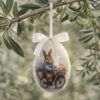 Uovo pasquale decorativo Blanc Mariclo con coniglietto in bicicletta, fiori pastello e fiocco in raso avorio.