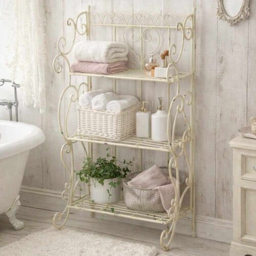 Scaffale in metallo avorio anticatato con tre ripiani a griglia, decori a ricciolo e cuore centrale, stile shabby chic.