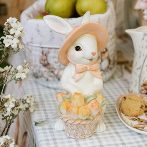 Coniglietta decorativa in resina con cappello rosa e cestino di fiori pastello.