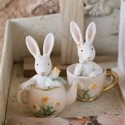 Coniglio PePen in resina su teiera o tazzina, decorazione pasquale assortita con dettagli floreali.